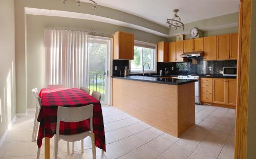a kitchen with a table with a red checkered table cloth at Nice rooms with private bath in Mid Town Toronto in Toronto