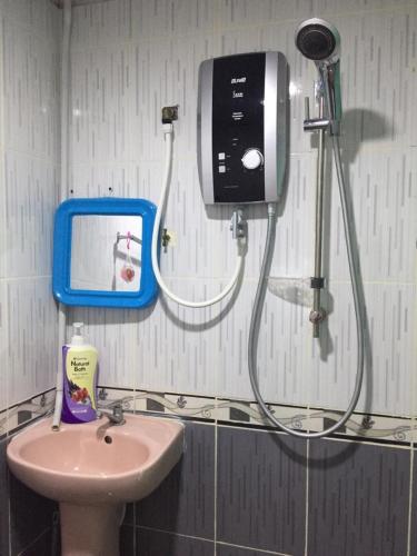 a bathroom with a soap dispenser and a sink at AMIMAS HOMESTAY in Kampong Bagan Samak