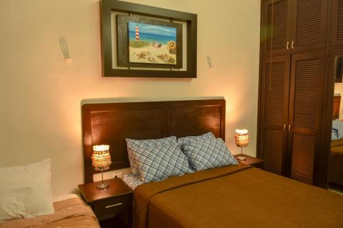 a bedroom with a bed and two lamps on tables at Casa Marisol in Cozumel