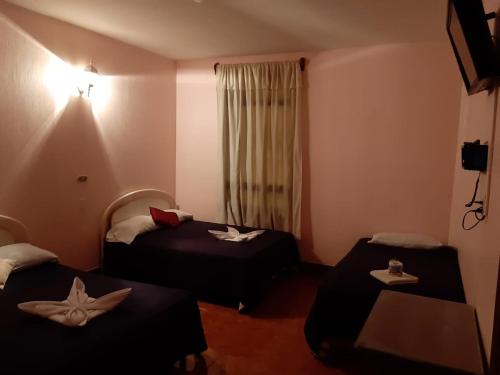 a hotel room with two beds and a window at Hotel Posada del Centro in Guatemala