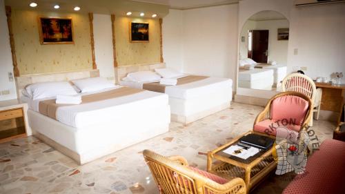 a room with two beds and a table and chairs at Clarkton Hotel Apartment in Angeles