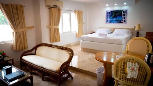 a bedroom with a bed and a chair and a table at Clarkton Hotel Apartment in Angeles