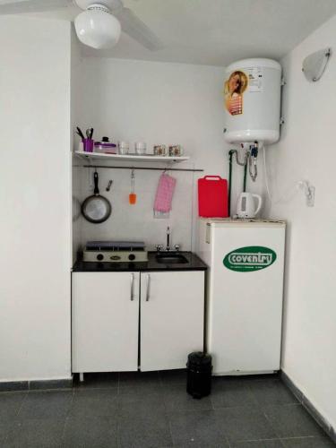 a small kitchen with a stove and a refrigerator at Monoambiente confortable a pasos de Bv. Oroño in Rosario