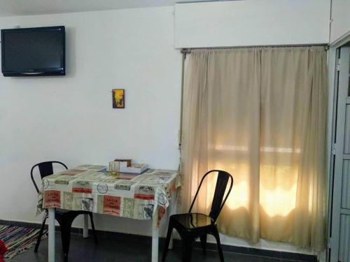 a dining room table with two chairs and a television at Monoambiente confortable a pasos de Bv. Oroño in Rosario