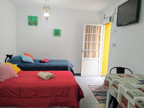 a bedroom with two beds and a tv on the wall at Monoambiente confortable a pasos de Bv. Oroño in Rosario