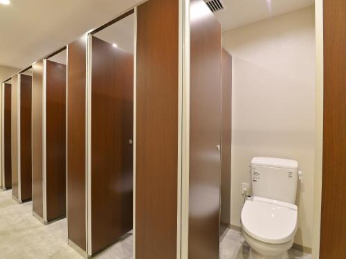 a bathroom with a toilet and wooden stalls at Gardens Cabin in Sapporo