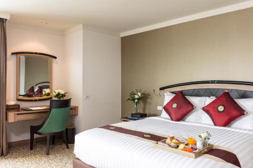a hotel room with a bed with a tray of food on it at Baiyoke Sky Hotel in Bangkok