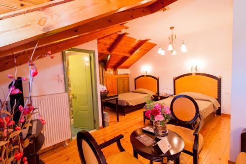 a room with two beds and a table and chairs at Krikonis Hotel in Ioannina