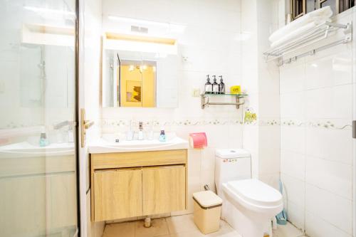 uma casa de banho branca com um lavatório e um WC em Henan Zhengzhou·Garden Road· em Zhengzhou