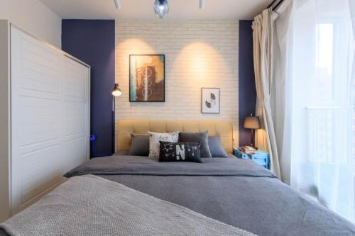 a bedroom with a large bed with blue walls at Baoding Jingxiu·BaoDing Railway Station· in Baoding