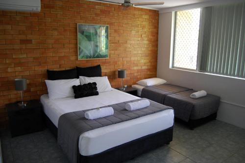 a hotel room with two beds and a window at Sunseeker Motel in Hervey Bay
