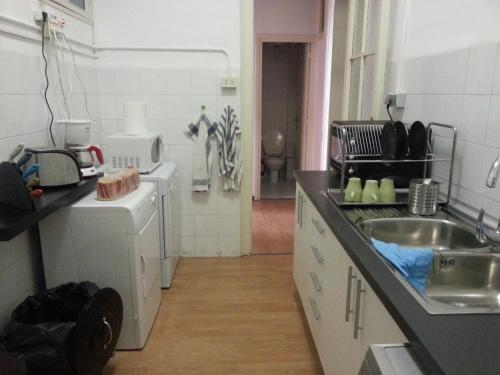 a kitchen with a sink and a washing machine at Fabrizzios Terrace Hostel in Barcelona