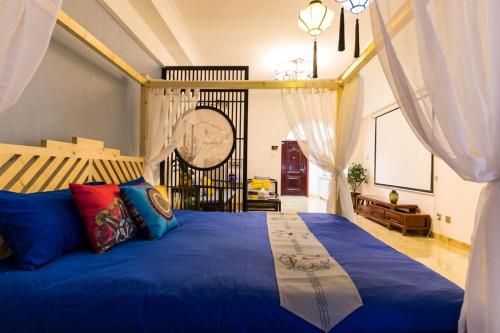 a bedroom with a large blue bed with curtains at XiNing Chengxi ·Limeng Pedestrian Street· in Xining