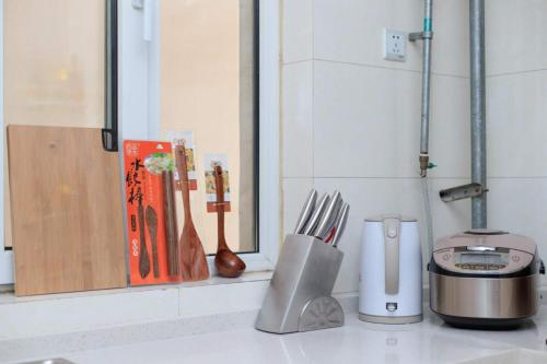 a kitchen counter with utensils on a counter top at Baoding Jingxiu·BaoDing Railway Station· in Baoding