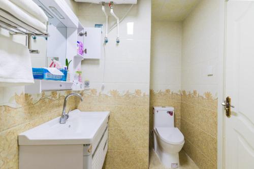 a bathroom with a toilet and a sink at XiNing Chengxi ·Wanda square· in Xining