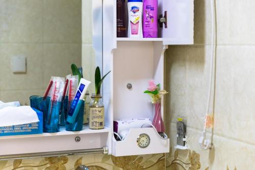 a bathroom shelf with toothbrushes and other items on it at XiNing Chengxi ·Limeng Pedestrian Street· in Xining