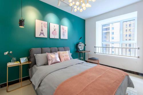 a bedroom with a bed and a green wall at Baoding Lianchi·Baoding East Station· Locals Apartment 00163450 in Baoding