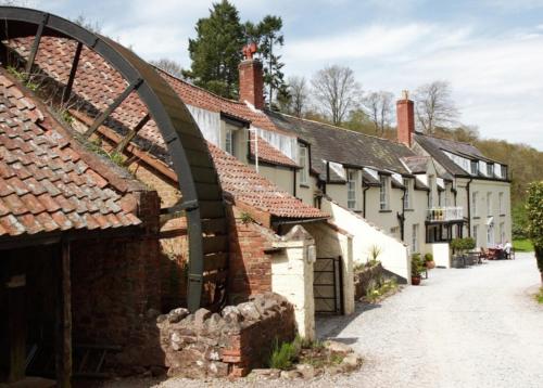 an old street in a village with buildings at Combe House Hotel in Holford