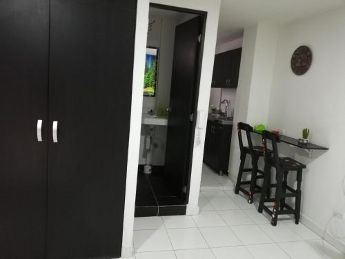 a kitchen with a black door and a table and chairs at APARTA ESTUDIO 7051 in Medellín