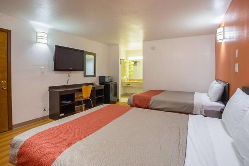 ein Hotelzimmer mit 2 Betten und einem Flachbild-TV in der Unterkunft Motel 6-Brinkley, AR in Brinkley