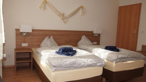 two beds in a room with blue towels on them at Gasthof Keilbach in Sindelfingen