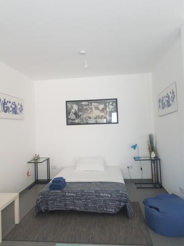 a white bedroom with a bed and two tables at Julia's Residence in Nicosia