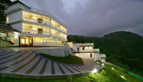 a large building with steps in front of it at night at Moonline Resort in Anaviratty