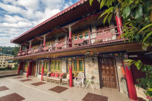 a building with chairs and tables in front of it at Netuk House a heritage boutique stay in Gangtok