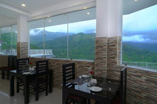 a restaurant with tables and chairs and a large window at Moonline Resort in Anaviratty