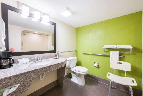 a bathroom with a toilet and a sink and a mirror at Sleep Inn Statesville I-40 in Statesville