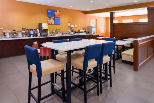 a dining room with tables and blue chairs at Holiday Inn Express & Suites Joplin Southeast by IHG in Joplin