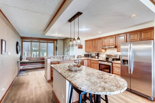 eine Küche mit Kühlschrank und Arbeitsplatte in der Unterkunft Spacious And Modern 2Br Premier- The Pines- Kids Ski Free Condo in Keystone