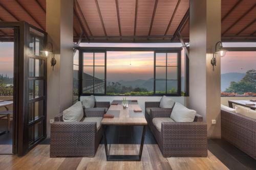 a living room with two couches and a table at Nava Hotel Tawangmangu in Tawangmangu