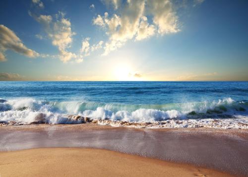 a beach with the ocean and the sun setting at BURSZTYN - BERNSTEIN SPA & Wellness in Dąbki