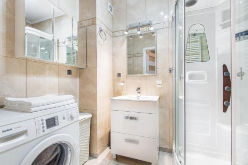 łazienka z pralką i prysznicem w obiekcie Super-Apartamenty Targi Poznańskie w Poznaniu
