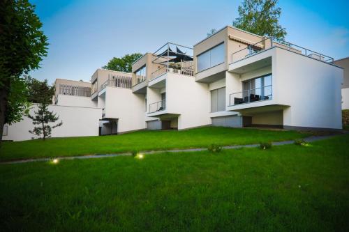 a large white building with a green yard at Słoneczny Cypel in Gródek Nad Dunajcem