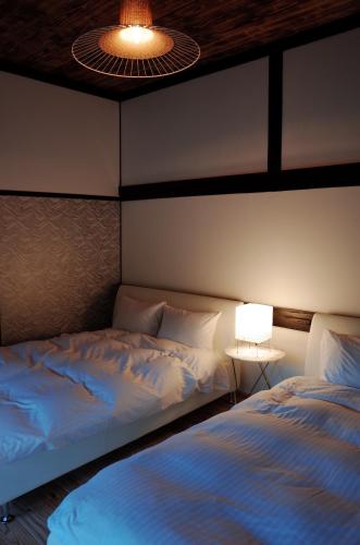五島的住宿－Okune，一间卧室配有两张床、一盏灯和一盏灯。