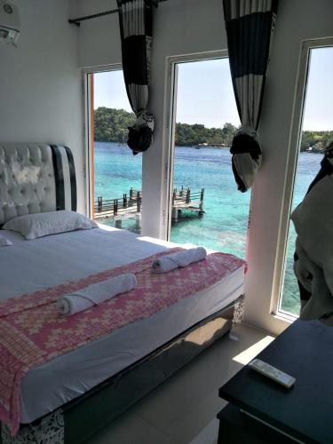 a bedroom with a bed with a view of the ocean at Mr. Bean Resort in Sabong