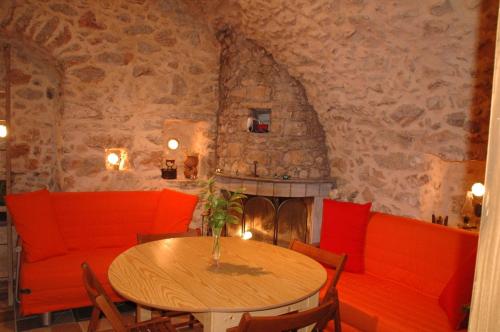 a dining room with a table and a fireplace at Stoneapartments, Γ ΚΩΣΤΑΛΟΣ ΚΑΙ ΣΙΑ ΟΕ in Avgonyma
