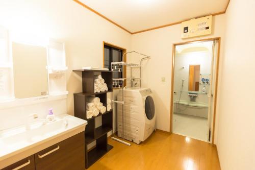 a bathroom with a sink and a washing machine at Airstar Chiyo House x M&Z HOUSE in Fukuoka