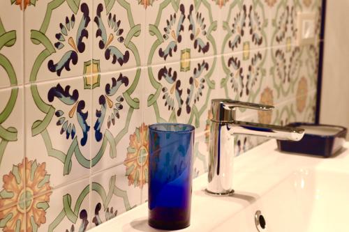 um copo azul sentado num lavatório ao lado de uma torneira em Masseria Torca - Isca em Massa Lubrense