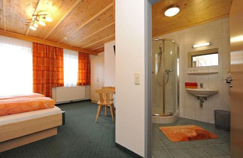 een slaapkamer met een bed, een douche en een wastafel bij Gästehaus Standardhaus in Saalbach Hinterglemm
