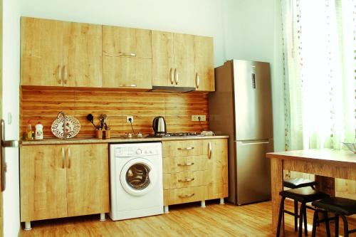 a kitchen with a washing machine and a refrigerator at Guest House Irakli in Makhinjauri