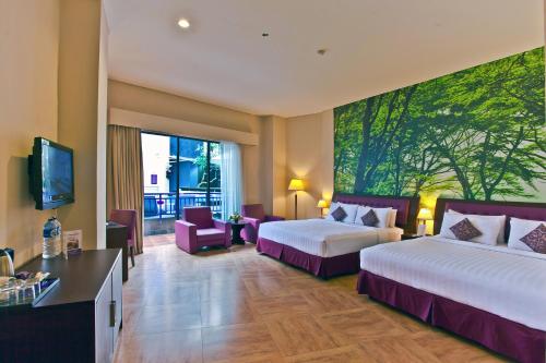 Tempat tidur dalam kamar di Kuta Central Park Hotel