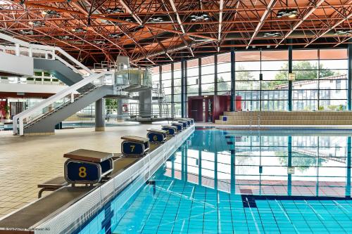 a large swimming pool with a row ofools in it at Taste Hotel Heidenheim in Heidenheim