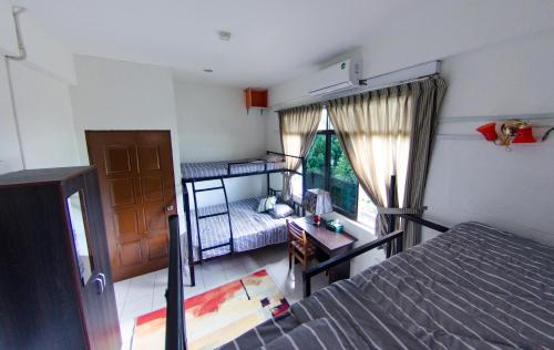 a bedroom with two bunk beds and a desk at Poni Homestay in Bandar Seri Begawan