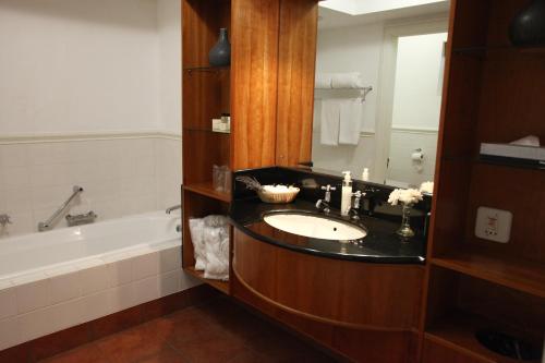 ein Badezimmer mit einem Waschbecken und einer Badewanne in der Unterkunft Zevenwacht Country Inn in Kuilsrivier