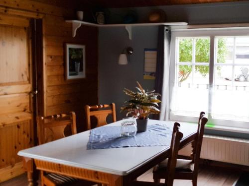 a dining room with a table and chairs and a window at Ferienhaus Fröhlich in Ladelund