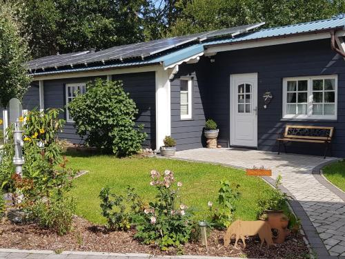 a small blue house with a garden in front of it at Ferienhaus Fröhlich in Ladelund