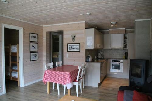 een keuken en eetkamer met een tafel en stoelen bij Myrkdalen Resort Øvre Bygardslii apartment in Vossestrand